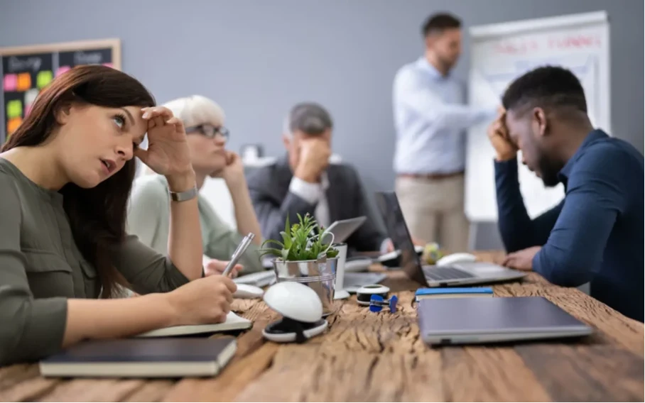 Mitarbeiter wirken energielos im Teammeeting